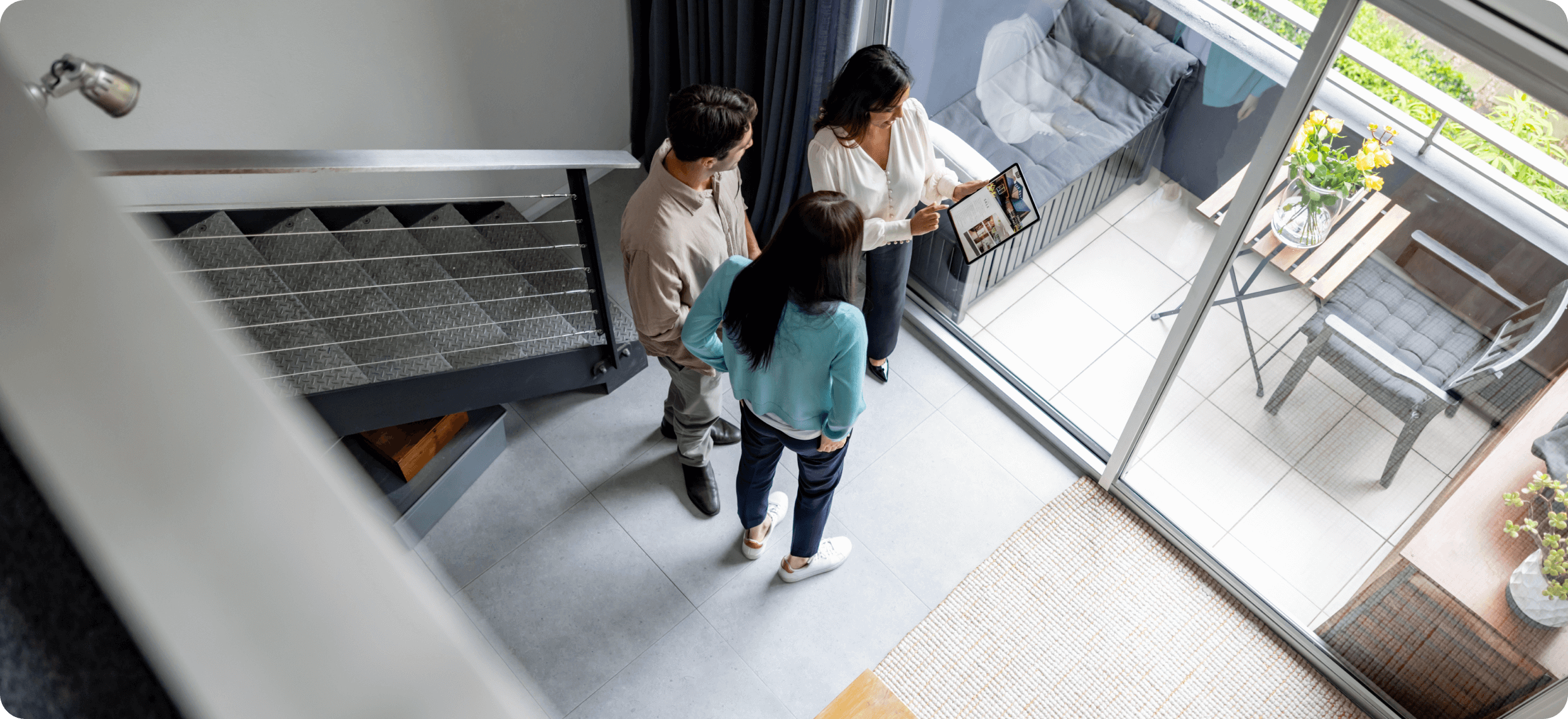 People viewing modern apartment with balcony.